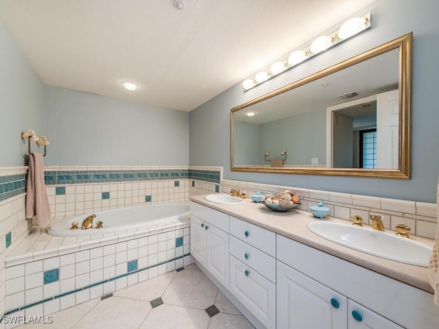 bathroom with tile patterned flooring, vanity, and a relaxing tiled tub