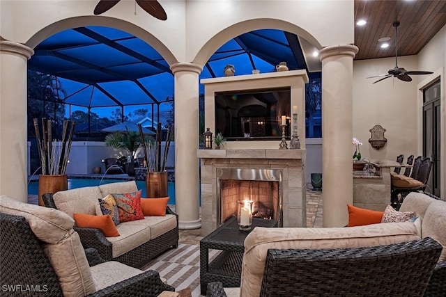 view of patio with a fireplace, pool water feature, glass enclosure, and ceiling fan