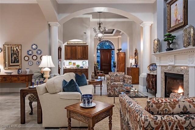 living room with ornamental molding, a notable chandelier, and a premium fireplace