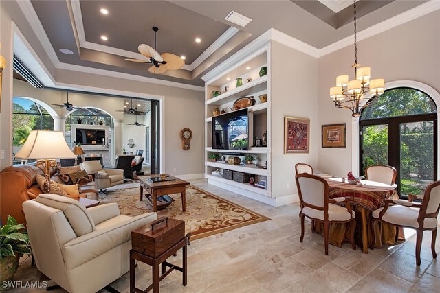 living room featuring ceiling fan with notable chandelier, built in features, crown molding, and a wealth of natural light