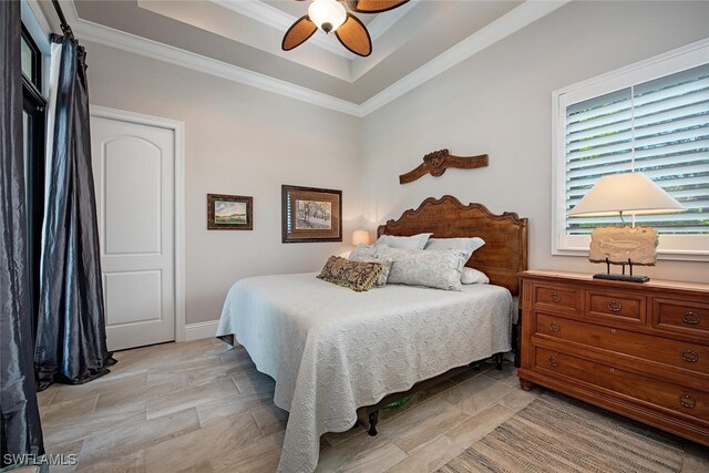 bedroom with a raised ceiling, ceiling fan, and ornamental molding