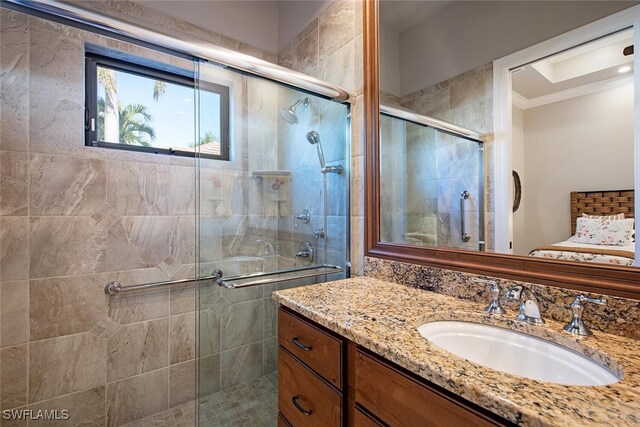 bathroom with vanity, a shower with door, and crown molding