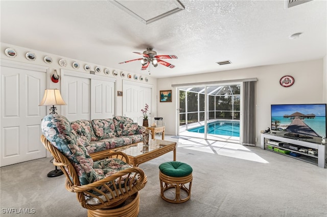 carpeted living room with a textured ceiling and ceiling fan