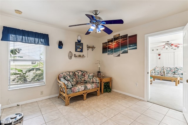 living area with light tile patterned floors and ceiling fan