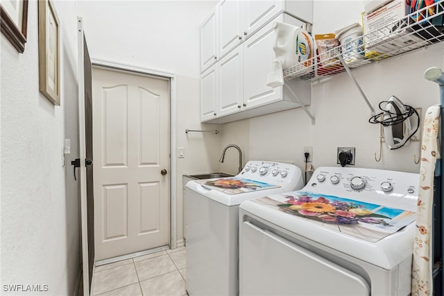 washroom featuring cabinets, sink, washer and dryer, and light tile patterned floors