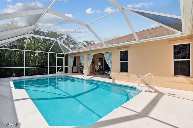 view of swimming pool with a patio area and a lanai