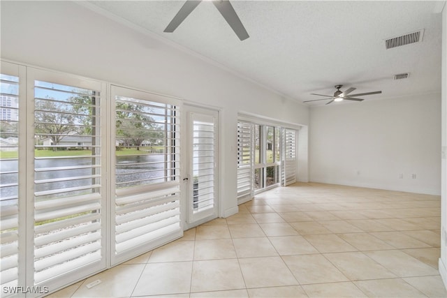 tiled empty room featuring a water view and a textured ceiling