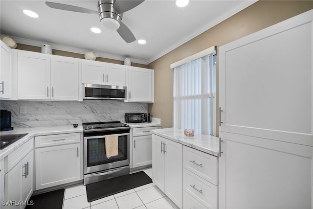 kitchen with tasteful backsplash, crown molding, stainless steel appliances, white cabinets, and ceiling fan