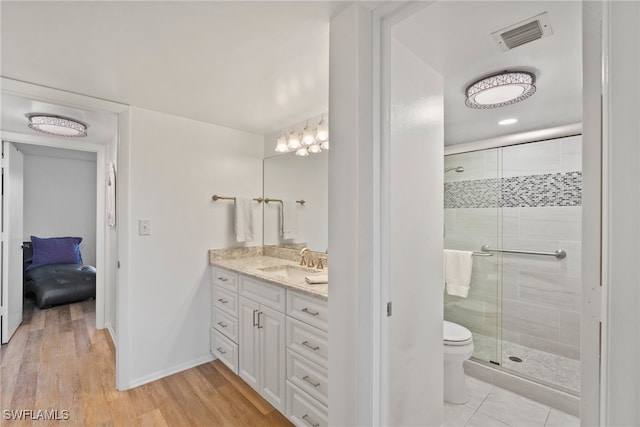 bathroom with toilet, vanity, wood-type flooring, and walk in shower