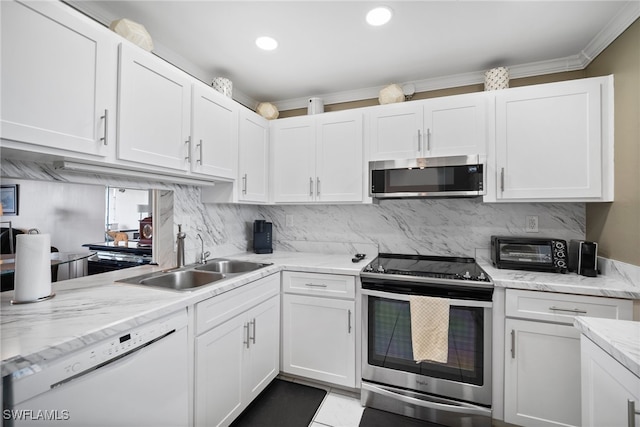 kitchen featuring appliances with stainless steel finishes, sink, crown molding, and white cabinets