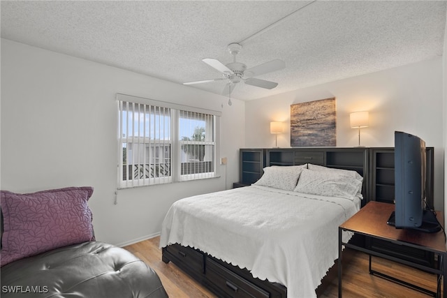 bedroom featuring hardwood / wood-style floors, ceiling fan, and a textured ceiling