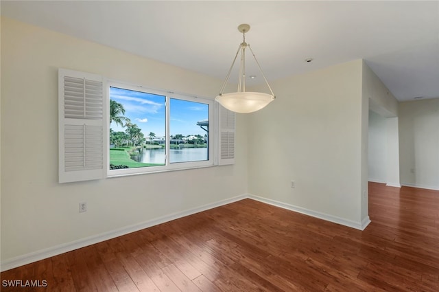 unfurnished dining area with a water view and hardwood / wood-style flooring