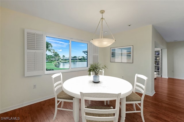 dining space with a water view and wood-type flooring