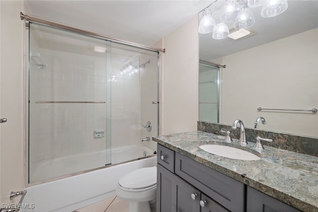 full bathroom with tile patterned flooring, shower / bath combination with glass door, toilet, and vanity