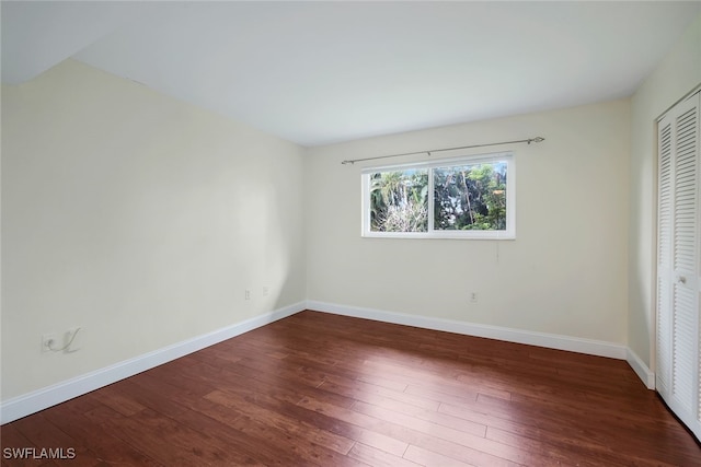 unfurnished bedroom featuring dark hardwood / wood-style floors and a closet