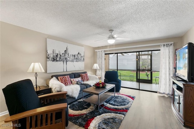 living room with a textured ceiling, hardwood / wood-style flooring, and ceiling fan