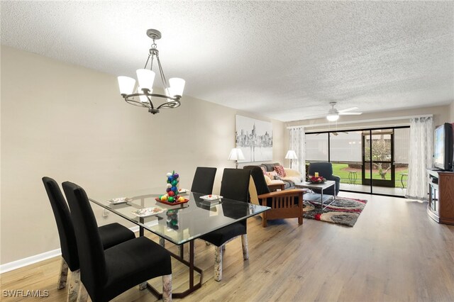 dining area featuring ceiling fan with notable chandelier, light hardwood / wood-style floors, and a textured ceiling