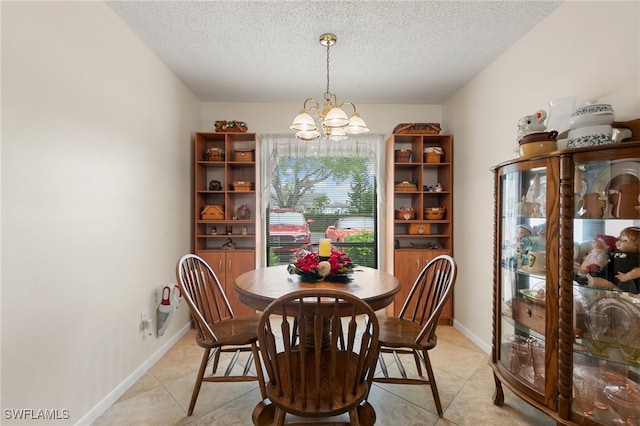 dining space featuring light tile patterned floors, a textured ceiling, and a notable chandelier