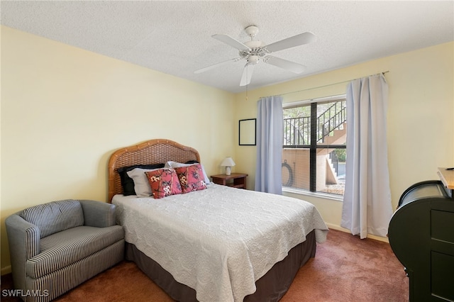 carpeted bedroom with ceiling fan and a textured ceiling