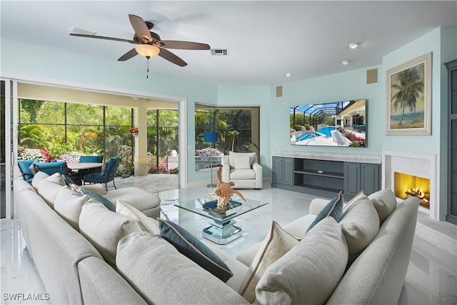 living room with a fireplace and ceiling fan