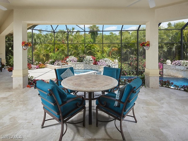 view of patio featuring ceiling fan and glass enclosure