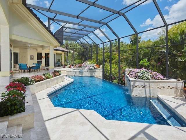 view of swimming pool featuring a hot tub, pool water feature, ceiling fan, a lanai, and a patio