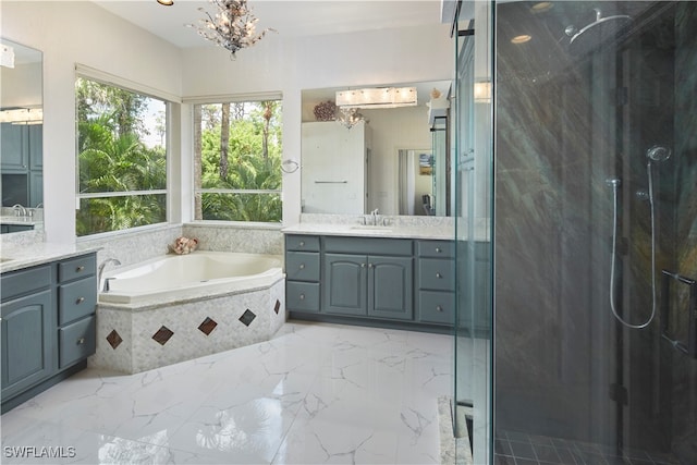 bathroom featuring separate shower and tub, a chandelier, and vanity