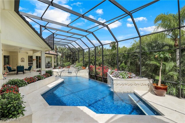 view of swimming pool featuring ceiling fan, a lanai, a patio, and pool water feature