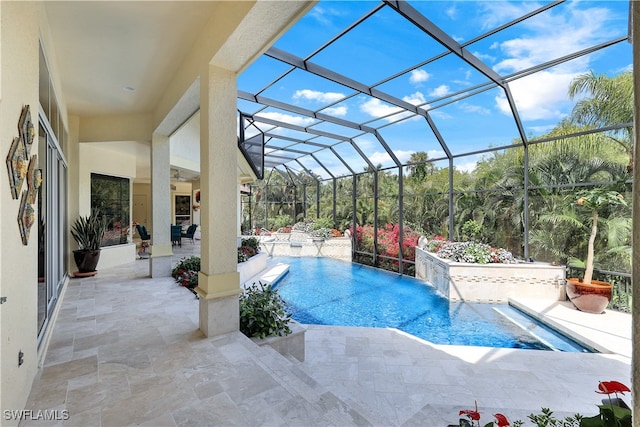 view of pool with a lanai, a patio, and pool water feature