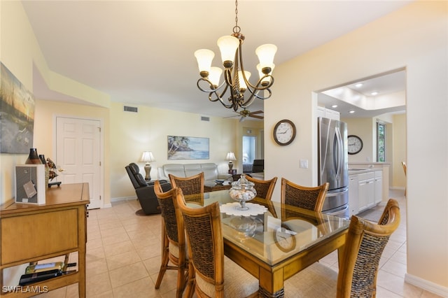 tiled dining area with ceiling fan with notable chandelier