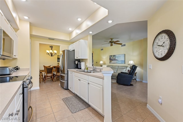 kitchen featuring stainless steel appliances, ceiling fan with notable chandelier, white cabinetry, and light tile patterned floors