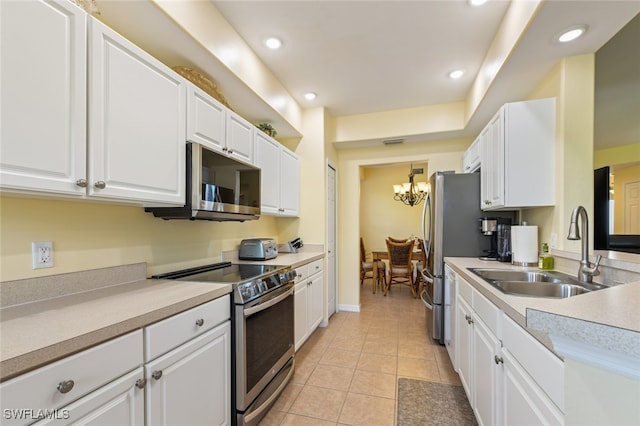 kitchen featuring light tile patterned floors, white cabinetry, sink, and appliances with stainless steel finishes