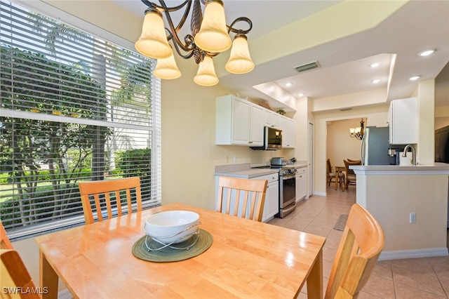 dining area with light tile patterned floors, sink, and an inviting chandelier