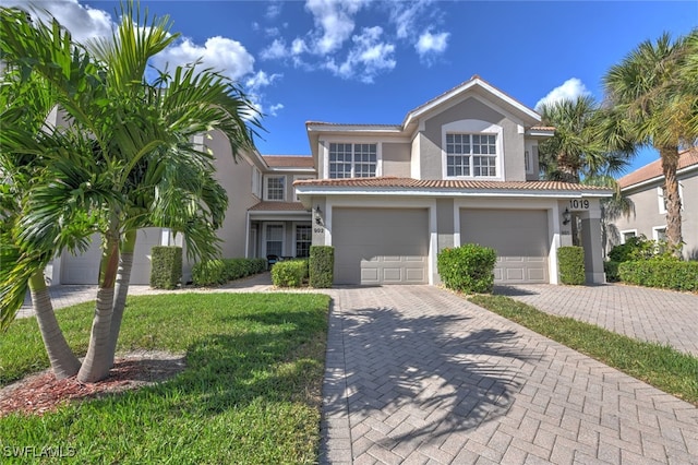 mediterranean / spanish house with a garage and a front yard