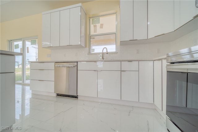 kitchen featuring backsplash, stainless steel appliances, and white cabinets