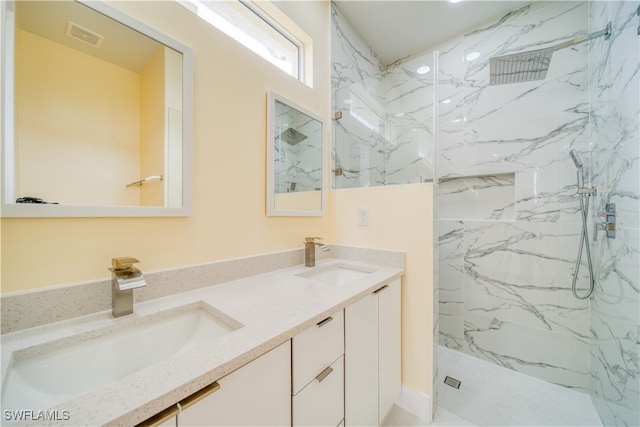 bathroom with tiled shower and vanity