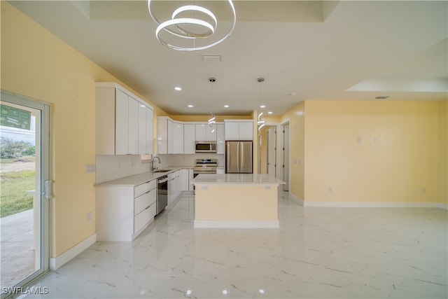 kitchen with white cabinetry, sink, appliances with stainless steel finishes, a center island, and pendant lighting