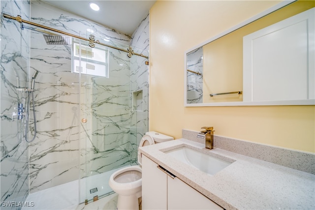 bathroom with a shower with shower door, vanity, and toilet