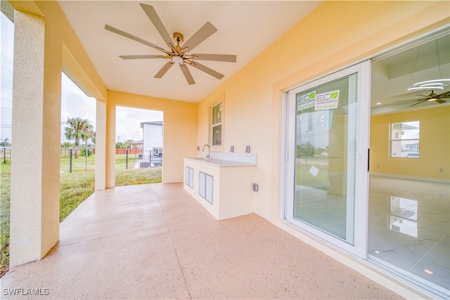 view of patio with ceiling fan and sink