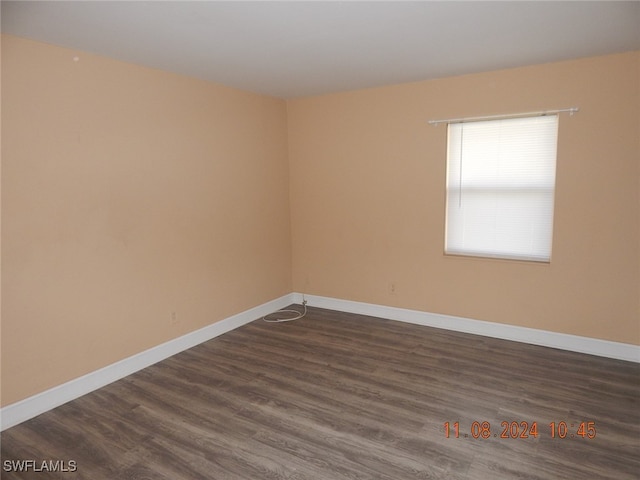 empty room with dark hardwood / wood-style flooring