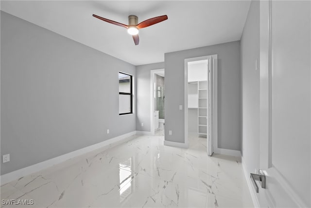 unfurnished bedroom featuring ensuite bathroom, ceiling fan, a walk in closet, and a closet