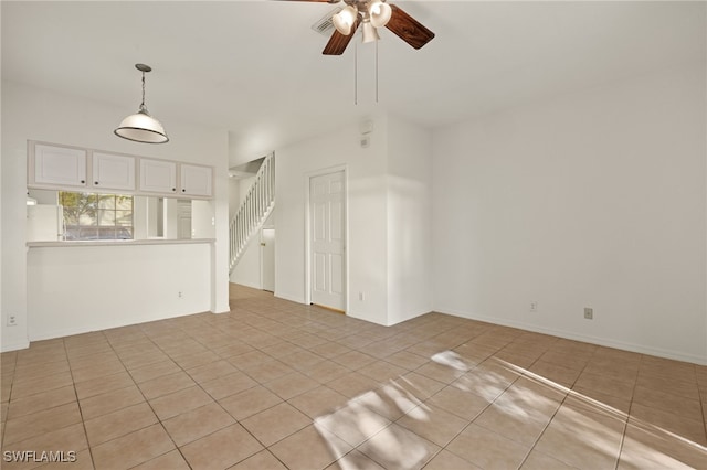 unfurnished living room featuring light tile patterned floors and ceiling fan