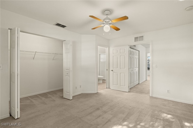 unfurnished bedroom with ensuite bath, ceiling fan, and light colored carpet