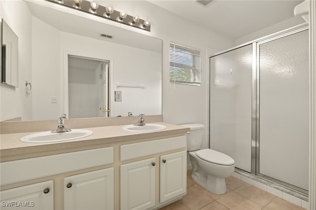 bathroom with tile patterned floors, vanity, toilet, and walk in shower