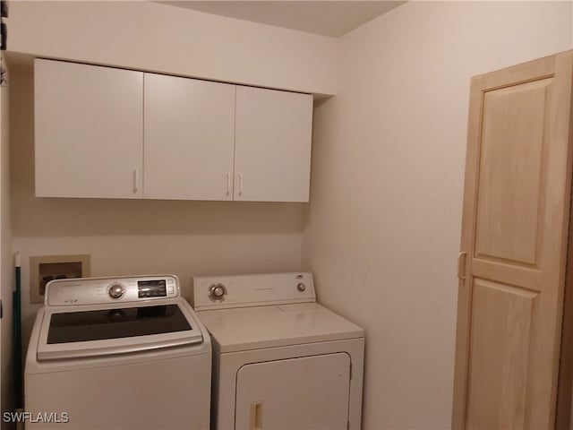 laundry area featuring separate washer and dryer and cabinets