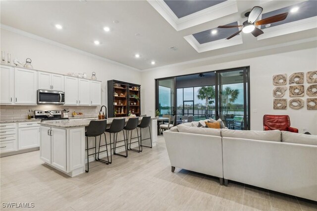 living room with ceiling fan and ornamental molding