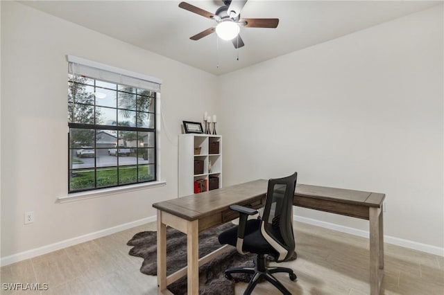 office area with wood finished floors, baseboards, and ceiling fan