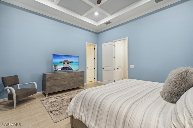 bedroom with visible vents, baseboards, wood finish floors, a high ceiling, and coffered ceiling