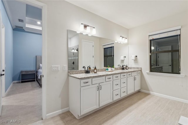 ensuite bathroom featuring visible vents, a sink, ensuite bath, a shower stall, and double vanity