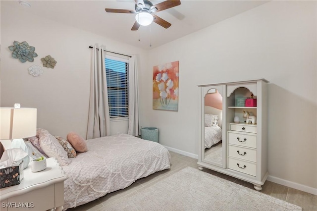 bedroom with ceiling fan and baseboards